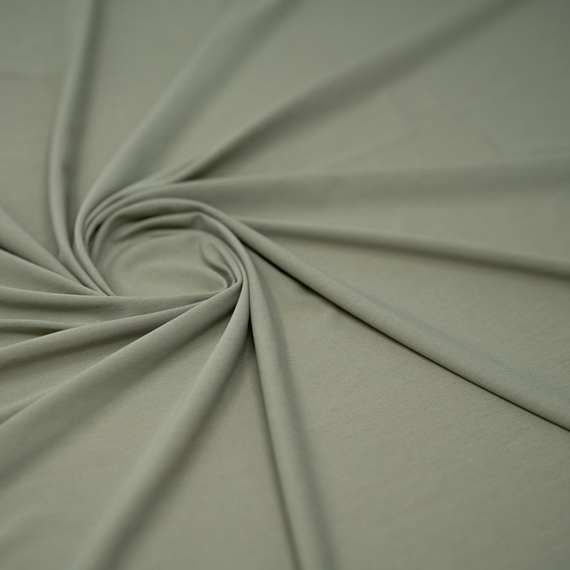 Detailed shot of swirled UniFlex Nylon Polyester Spandex Reversible Knit Top Weight Fabric in color Khaki Green.. 