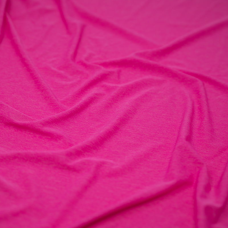 Detailed shot of UniFlex Nylon Polyester Spandex Reversible Knit Top Weight Fabric in color Positive Pink. 
