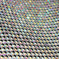 A flat sample of rhinestone aluminum scale mesh in iridescent tones.
