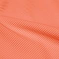 A rippled piece of Ribbed Spandex in the color cantaloupe.