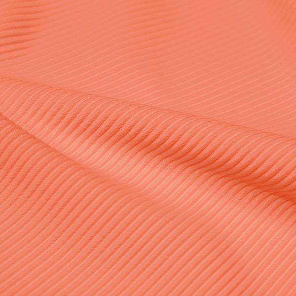 A rippled piece of Ribbed Spandex in the color cantaloupe.