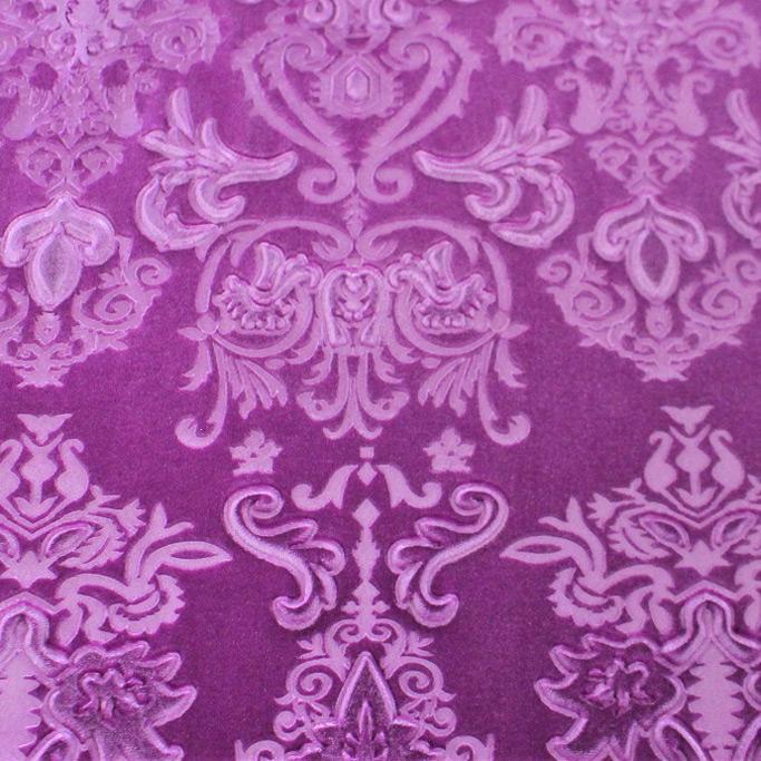 A flat sample of royalty embossed tretch velver in the color magenta pink.