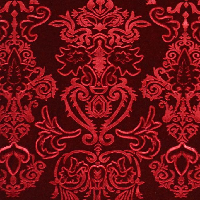 A flat sample of royalty embossed tretch velver in the color red.