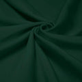 A swirled piece of shiny nylon spandex in the color alpine green.