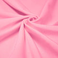 A swirled piece of shiny nylon spandex in the color cotton candy.