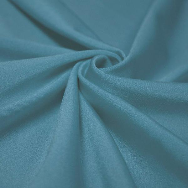 A swirled piece of shiny nylon spandex in the color jean.