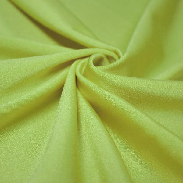 A swirled piece of shiny nylon spandex in the color lime.