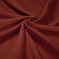 A swirled piece of shiny nylon spandex in the color mars.