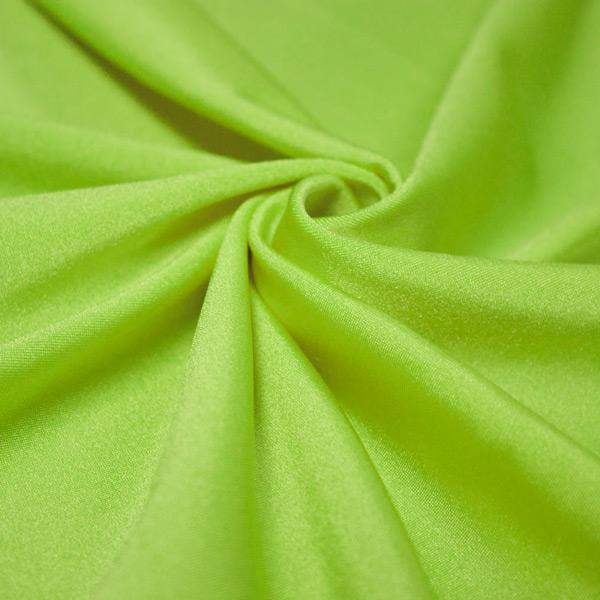 A swirled piece of shiny nylon spandex in the color neon lime.