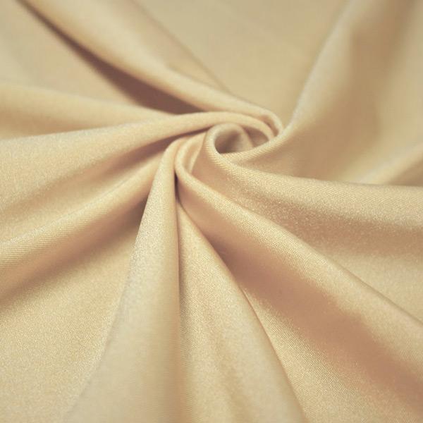 A swirled piece of shiny nylon spandex in the color nude.