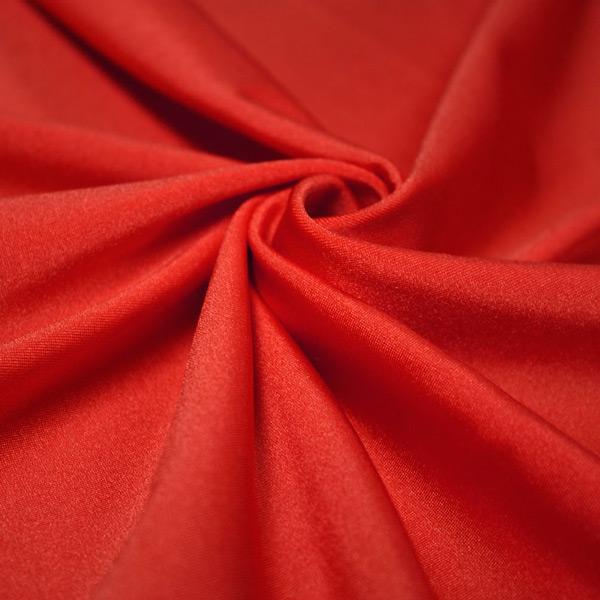 A swirled piece of shiny nylon spandex in the color red.