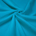 A swirled piece of shiny nylon spandex in the color turquoise.