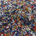A swirled sample of skittles sequin spandex in the color deep sea blue.