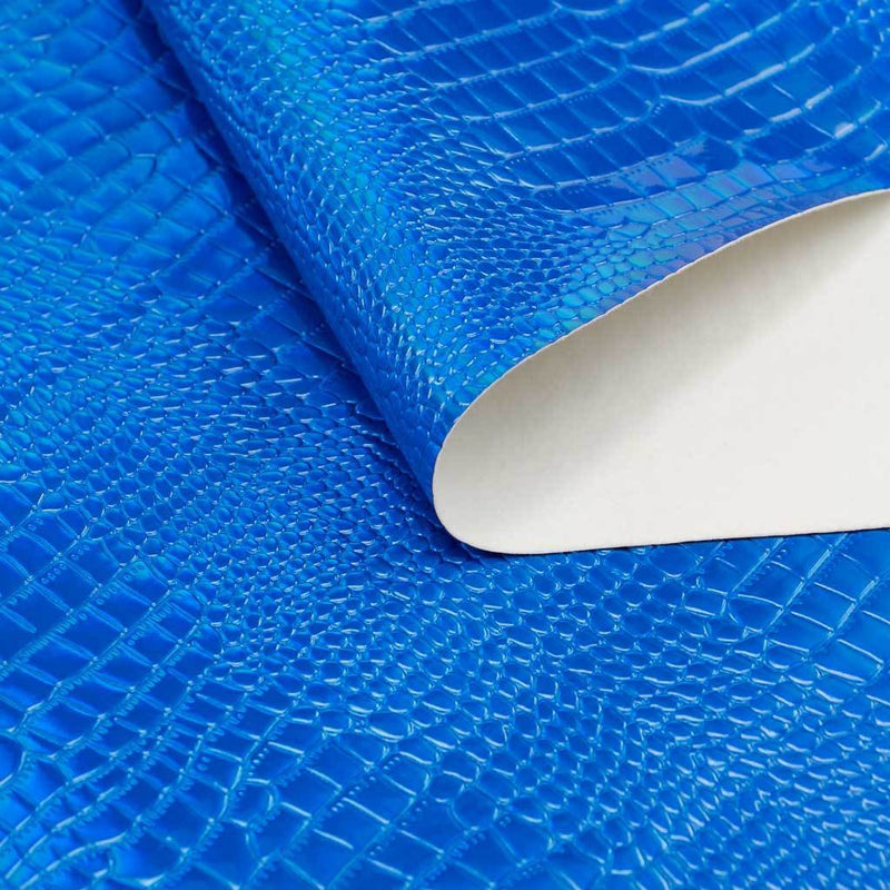 A folded sample of slyther embossed holographic vinyl in the color blue.