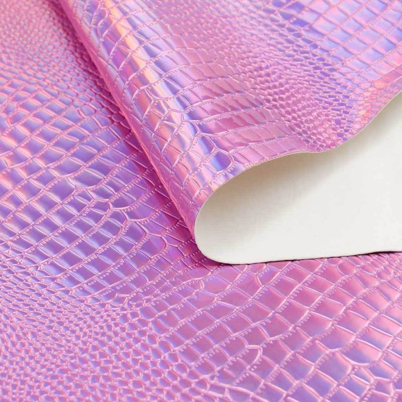 A folded sample of slyther embossed holographic vinyl in the color pink.