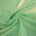 A swirled sample of sparkly foiled spandex in the color green gold.