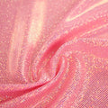 A swirled sample of sparkly foiled spandex in the color hot pink.