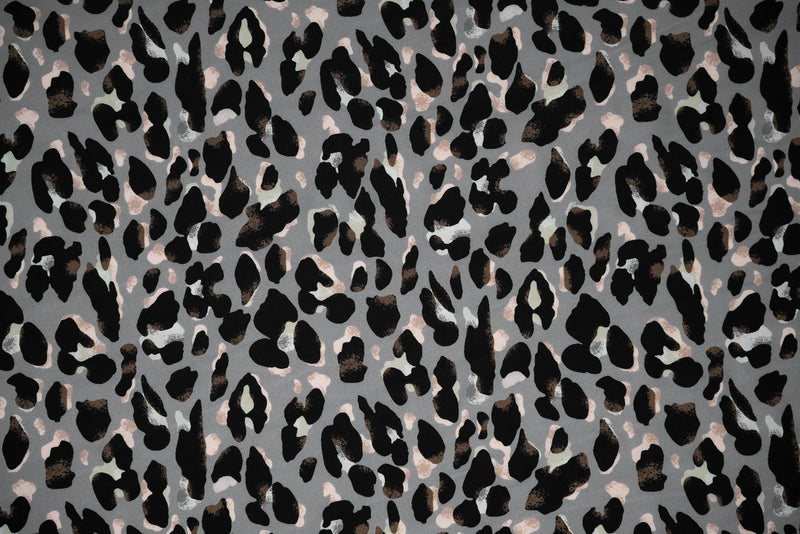 Flat sample shot of Sporty Leopard Printed Spandex Fabric. The print is of black leopard spots with light dust brown accents and light colored shadows on a gray background.