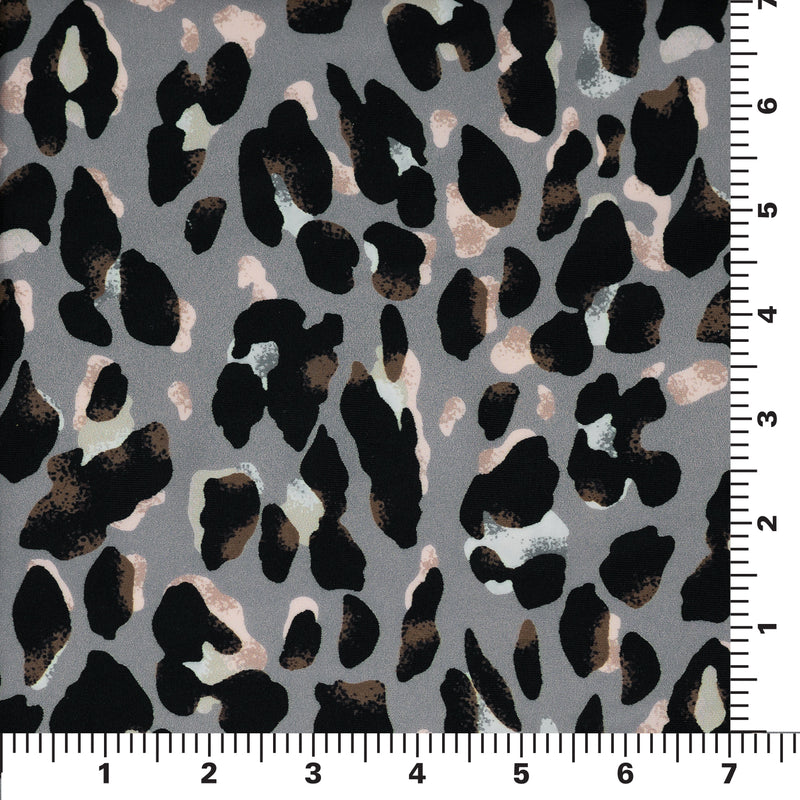Flat sample shot of Sporty Leopard Printed Spandex Fabric on a 7"x7" ruler for scale perspective. The print is of black leopard spots with light dust brown accents and light colored shadows on a gray background.