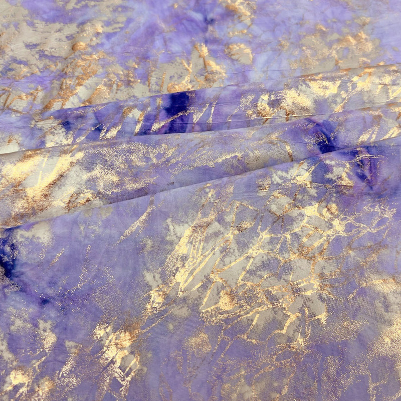 A folded sample of squall foiled tie-dye spandex in the color Lt. Purple Gold