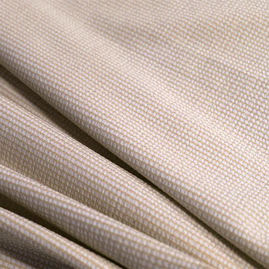 A rippled piece of stretch seersucker material in the color taupe.