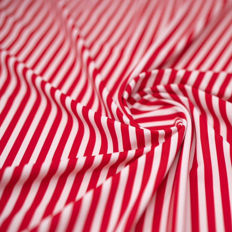 A swirled piece of Striped 1/4" Printed Spandex in the color Red and White