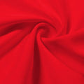 A swirled piece of Synergy Polyester Lycra in the color classic car red.