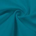 A swirled piece of Synergy Polyester Lycra in the color tropical teal.