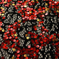 A flat sample of Tango Stretch Lace Sequin in the color Black-Red-Gold