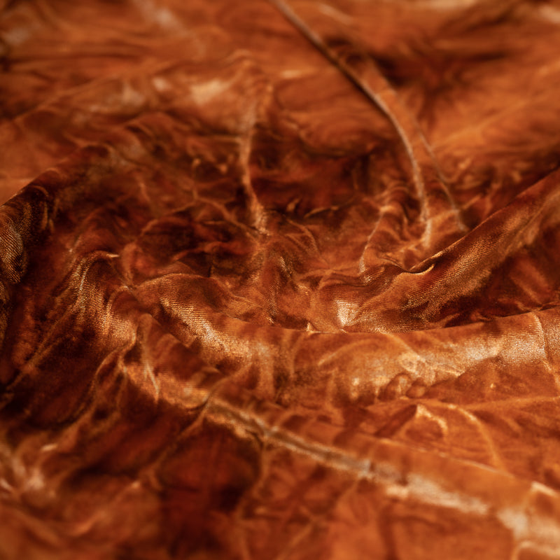 A piece of Tempest Tie Dye on Revival Crushed Stretch Velvet Fabric in color Rust