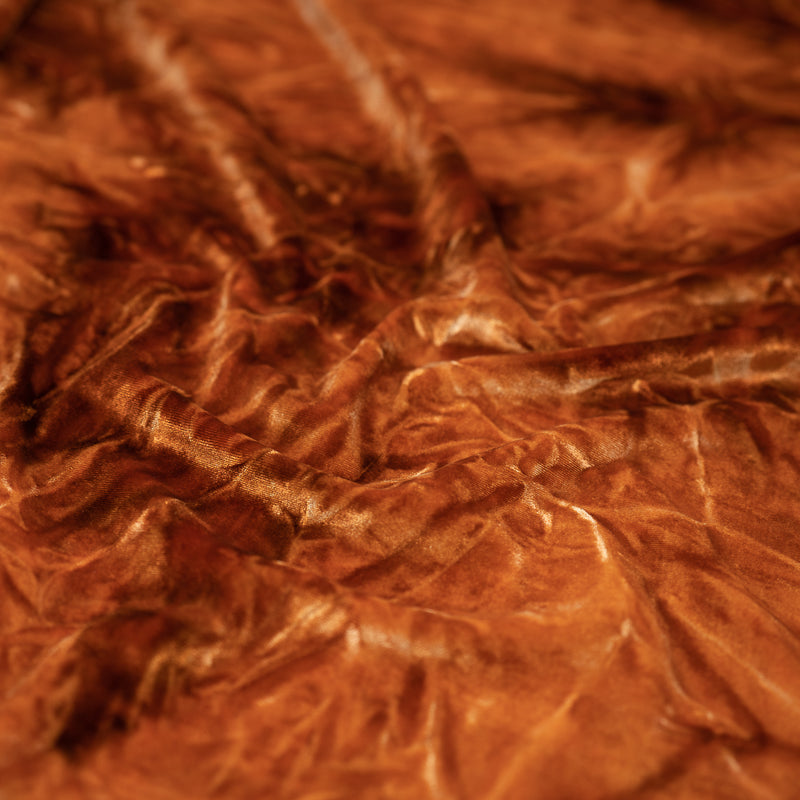 A piece of Tempest Tie Dye on Revival Crushed Stretch Velvet Fabric in color Rust