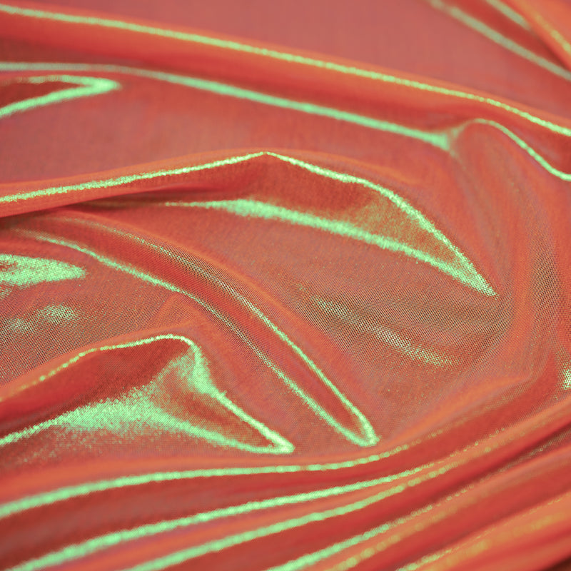 A swirled sample of ultrasheen foiled power mesh with a coral and oz foil available at Blue Moon Fabrics.