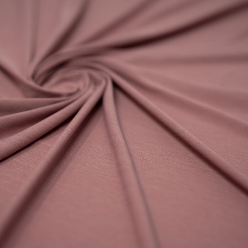 Shot of swirled UniFlex Nylon Polyester Spandex Reversible Knit Top Weight Fabric in color rose