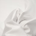 A swirled piece of nylon spandex fabric with an all over shiny look in the color White