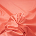 A swirled piece of nylon spandex fabric with an all over shiny look in the color Peachberry