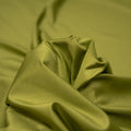 A swirled piece of nylon spandex fabric with an all over shiny look in the color Guacamole