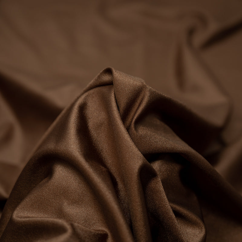 A swirled piece of nylon spandex fabric with an all over shiny look in the color rocky road