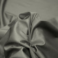 A swirled piece of nylon spandex fabric with an all over shiny look in the color gray
