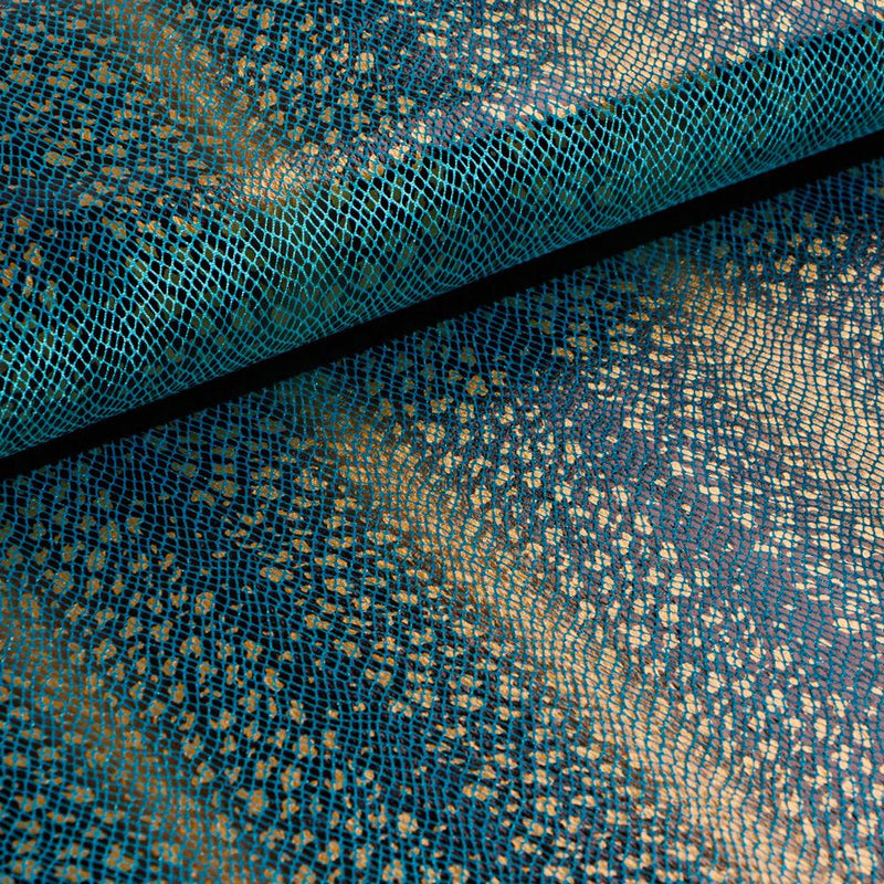 A folded sample of venomour foil printed stretch velvet in the color turquoise available at blue moon fabrics.