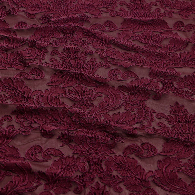 A flat sample of versailles burn out stretch velvet in the color burgundy.