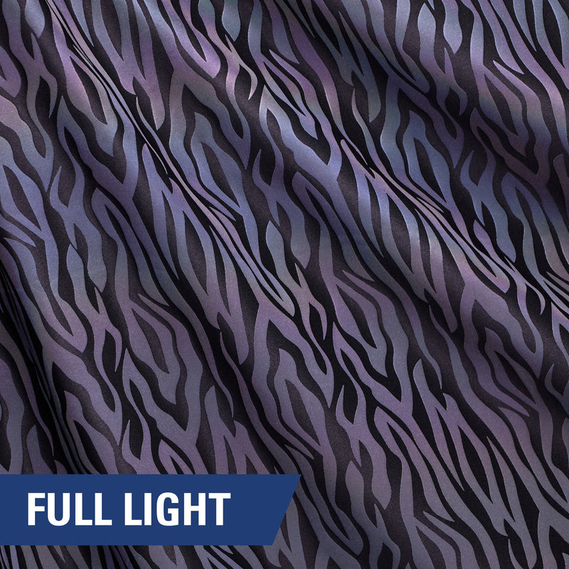 A rippled piece of Nocturnal Rainbow Reflective Spandex with a zebra stripe print under full light.
