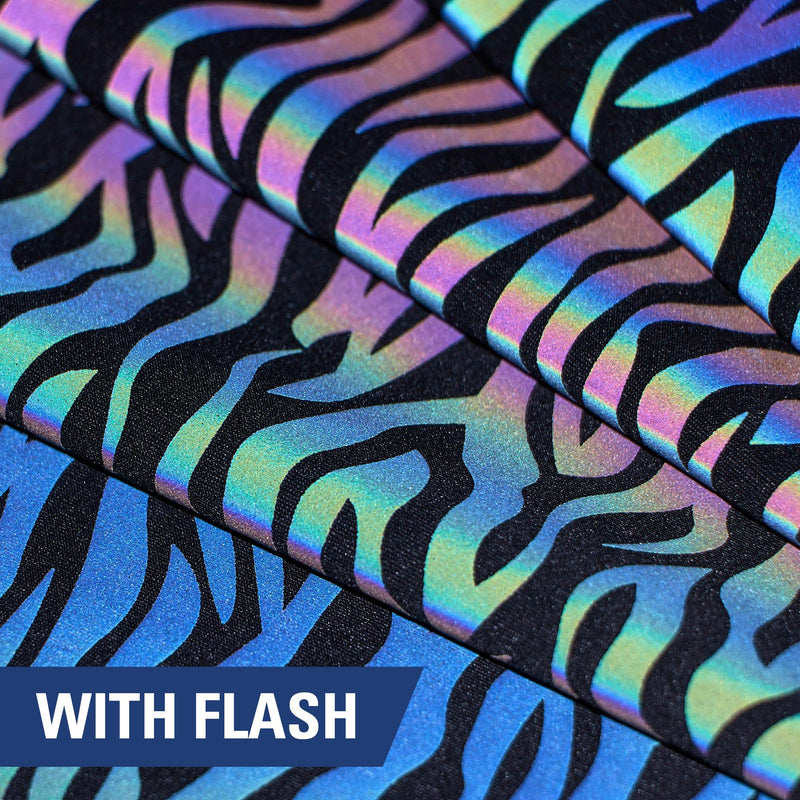 A folded piece of Nocturnal Rainbow Reflective Spandex with a zebra stripe print under a camera flash.