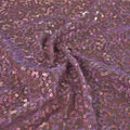 A swirled sample of zsa spa spandex sequin in the color mauve-light pink.