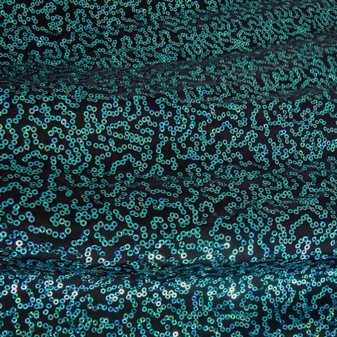 A swirled sample of zsa spa spandex sequin in the color navy turquoise.