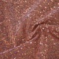 A swirled sample of zsa spa spandex sequin in the color topaz-light copper.
