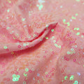 A swirled sample of zsa zsa pearl spandex sequin in the color pearl pink.
