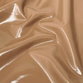 A swirled piece of polyurethane coated polyester spandex in the color nude.