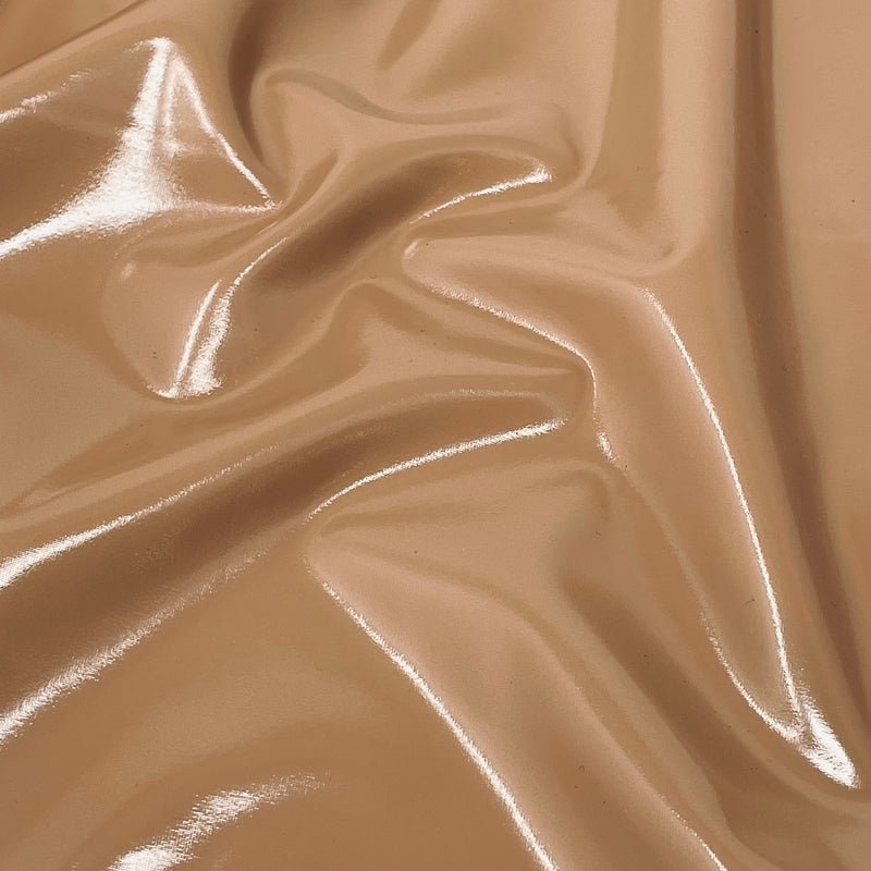 A swirled piece of polyurethane coated polyester spandex in the color nude.
